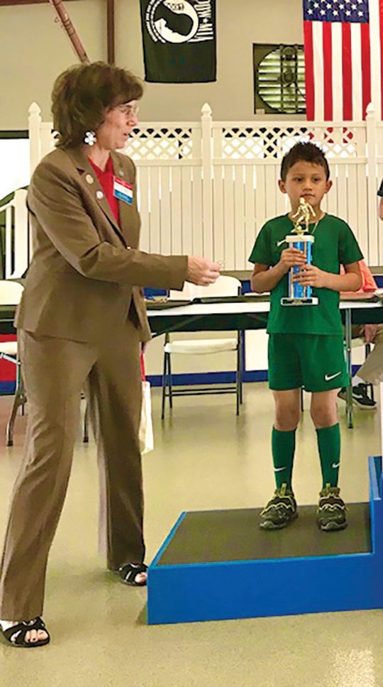 Jairo Santiago, from Clewiston, placed second in U-8 Boys. Jairo is pictured with Suzi Simonelli, Elks State President.